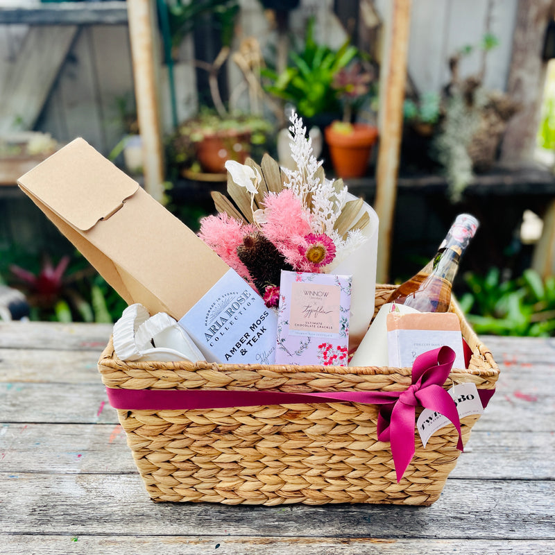 Seagrass Hamper Basket with simple ribbon finish with Dried flowers and a selection of gifts such as chocolates, a candle etc